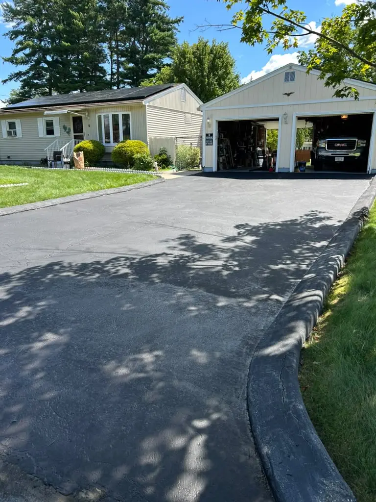Freshly paved black asphalt driveway leading to a home in Massachusetts